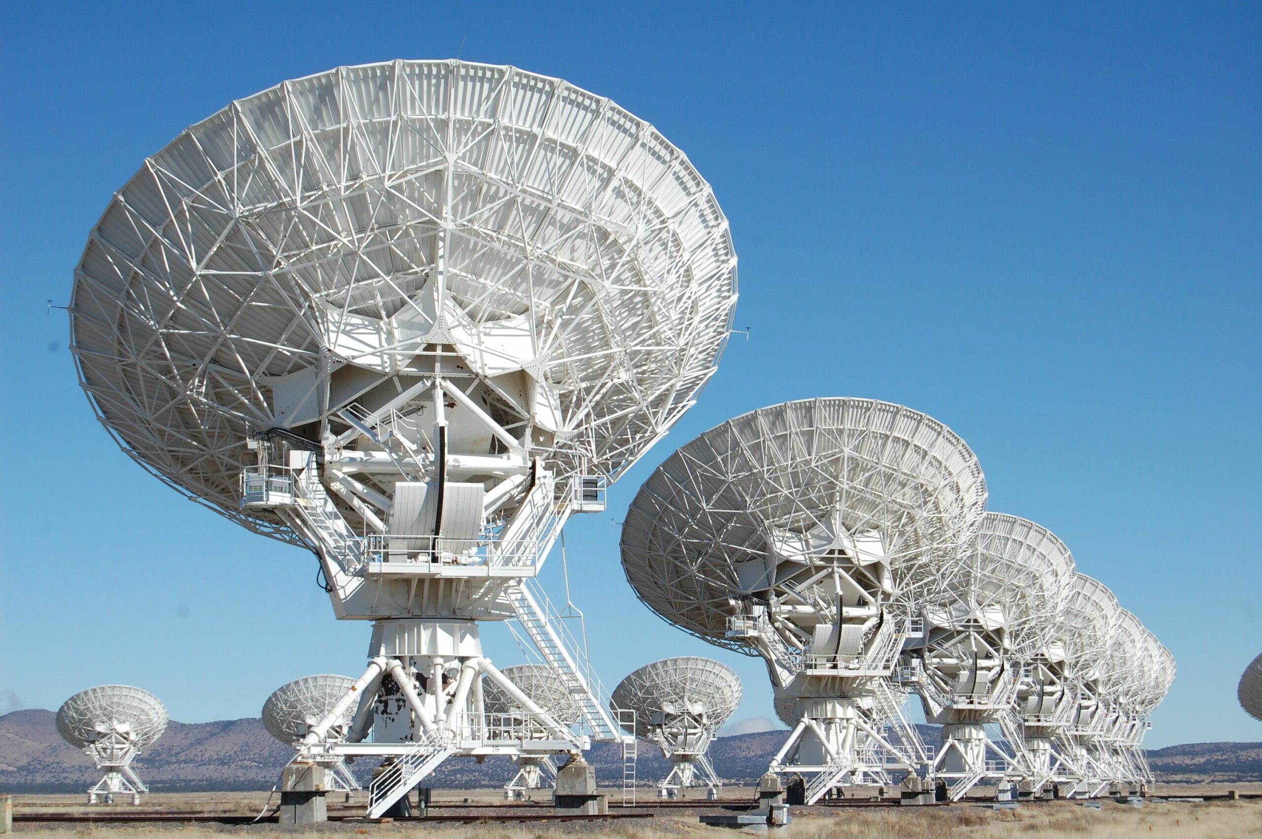 Picture of industrial size satellite dishes against a blue sky